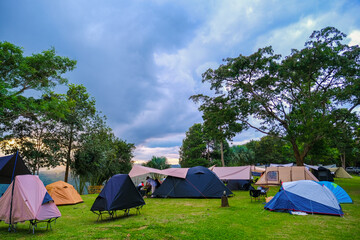 tourist tent camping in mountains at sunset, General view of tent with backpack and hiking equipment in forest, Fun floral and bunting covered canvas yurt tent in open field in California for wedding