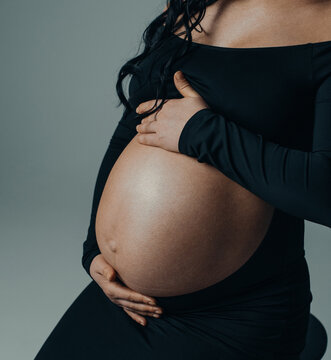 Close-up of pregnant woman belly with hands