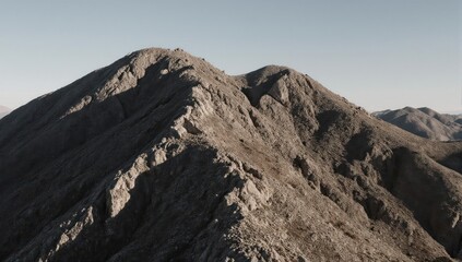 Rugged mountain peaks silhouetted against a bright, clear sky