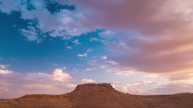 Timelapse: Ksar Beni Barka hilltop berber village at sunset, rocky desert landscape dramatic sky, ancient architecture, arid terrain, heritage, history, travel destination, Tataouine, Tunisia