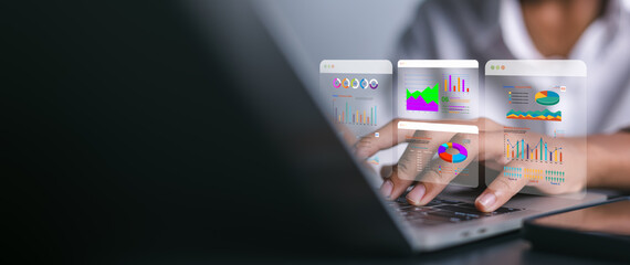 Close up businesswoman hands typing on laptop with holographic financial charts. Concept of data analysis, future fintech, accounting audit and marketing technology strategy.