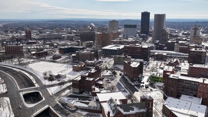 Rochester, NY downtown city skyline in Winter snow on office buildings and historic architecture dramatic aerial drone view