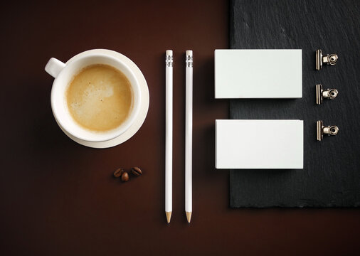 Blank stationery and coffee cup. Photo of blank business cards, pencils, coffee cup and binder clips. Flat lay.