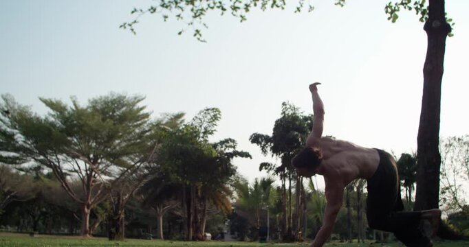 Cinematic 1000fps slow motion of an athlete using a hand-plant for momentum to execute a complex corkscrew backflip at sunset in Bangkok. Perfect body control in air. Concept skill technique motion