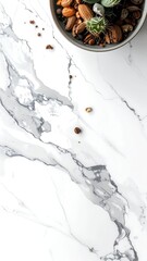 Overhead view of a small succulent terrarium arrangement on a white marble surface with scattered coffee beans and nuts.