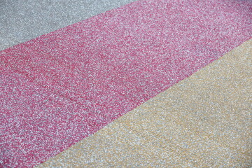 Fototapeta premium Rubber floor mats or fitness rubber floors in Red, yellow and gray, with red in center yellow and gray at edges. Rough surface, uneven color. Sports fields, fitness, playground, Divided diagonally. 