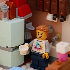 Obraz premium Tambov, Russian Federation - January 17, 2026 Lego man minifigure holding a white cup stands in a small kitchen.