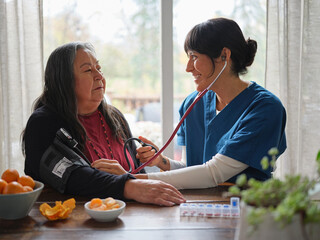 Native American nurse smiles at patient while taking blood pressure