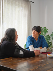 Native American nurse and patient chat after checking blood pressure at table