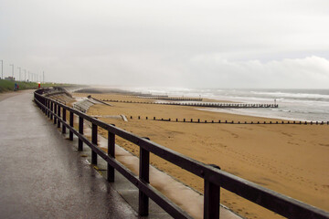 Obraz premium The deserted esplanade next to the Aberdeen Beach, Scotland, on a cold, wet rainy day.