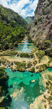 Aerial view of cascading turquoise waters flowing down a terraced landscape flanked by verdant cliffs, Semuc Champey, Antigua Guatemala, Sacatepequez Department, Guatemala.