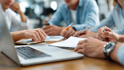 Team Collaboration in Action: Capturing a candid moment during a collaborative business meeting, individuals engage in focused discussions with laptops, documents, and other materials. - Powered by Adobe