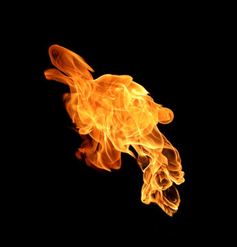 Single flowing fire flame isolated on black background, dynamic diagonal burning flame with strong heat and energy, abstract fire motion element for action, power, danger, FX, and creative design.