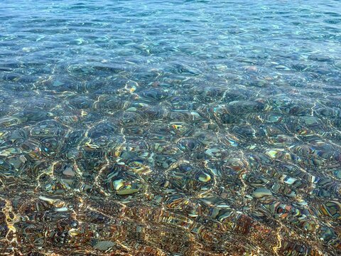 Clear sea with colorful pebbles at the bottom.