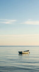 Naklejka premium Small wooden vessel drifts calmly upon tranquil ocean waters under a pale sky