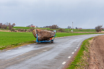 Small wooden boat on a broken trailer