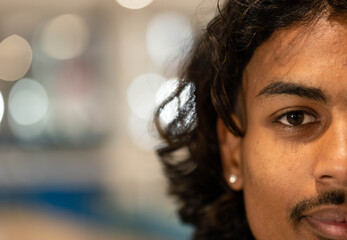 African American male gazing toward camera in studio with stud earring and bokeh lights