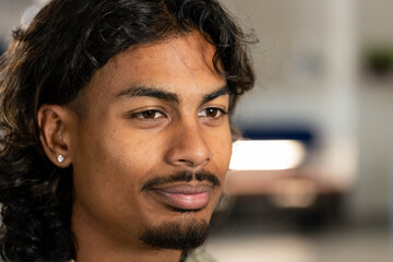African American man gazing slightly right in studio living area, showing stud earring and goatee