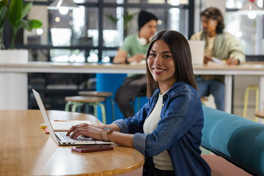African American peers working at workspace with woman typing laptop, denim, notebook, copy space