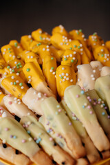 Chocolate dipped biscuit sticks with colorful sprinkles