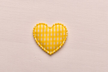 Yellow fabric heart shape on light background