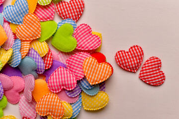 Colorful fabric heart shapes arranged on light surface