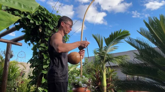 homem tocando birimbau som da capoeira 