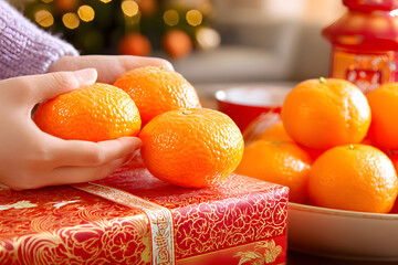 Gathering fresh oranges from a red gift box during a festive gathering in a cozy living room