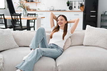Obraz premium Apartment, living room and person on couch for chilling, break and calm with confidence, pride and smile. Happy, home and portrait of woman on sofa for resting, relaxing and comfortable on weekend.