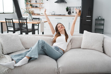 Apartment, woman and happy in portrait on sofa with peaceful, security or mortgage freedom. Young person, relax and smile in living room for comfortable break, insurance or wellness in home © InsideCreativeHouse