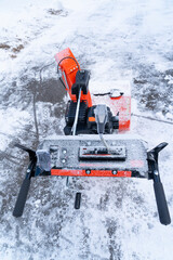 close up on snow blower removing snow on the driveway