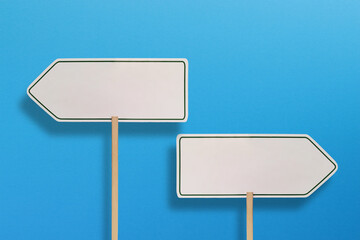 Two blank directional sign on blue background 