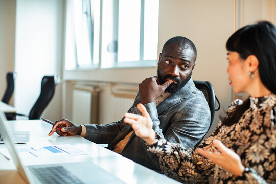 Two coworkers discussing project strategy in office