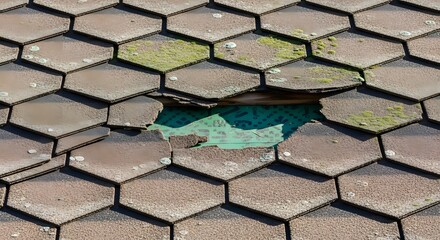 Broken hexagonal roof tiles with green moss and water puddle showing blue sky reflection broken tiles