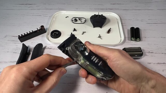 Disassembling a men's electric wireless razor and replacing old batteries - step 7 of 10, part of a series: removing from the handle of the plastic front part and the electronic board with the batteri
