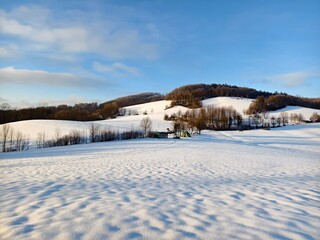 snowy landscape with field and hill