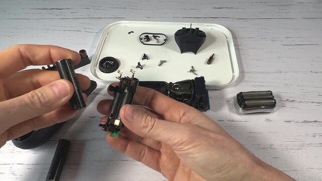 Disassembling a men's electric wireless razor and replacing old batteries - step 8 of 10, part of a series: battery replacement, two new batteries are put in