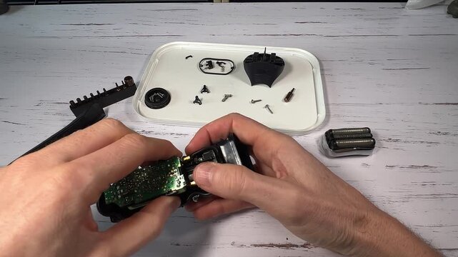 Disassembling a men's electric wireless razor and replacing old batteries - step 9 of 10, part of a series: reassembly phase, repositioning of the electronic board