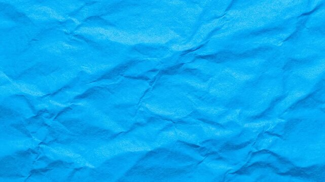 Bright Blue Crumbled Paper Texture - This video showcases a close-up of bright blue paper with a heavily crumpled texture.