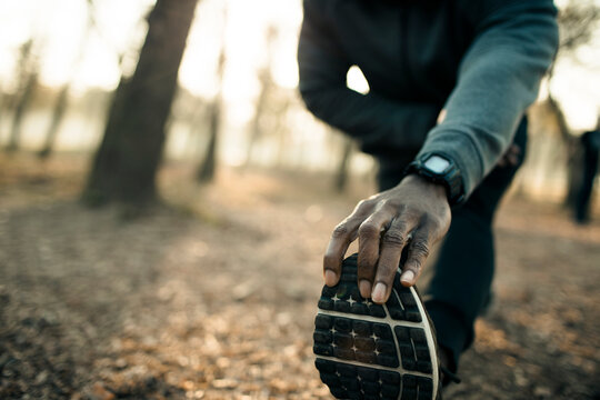 Athlete stretching before a run on a forest trail