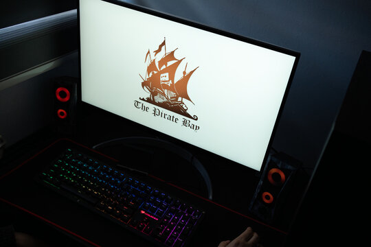 Punta Arenas, Chile &ndash; January 20, 2026: High-angle view of the Pirate Bay BitTorrent indexer interface on a PC screen with a backlit mechanical keyboard