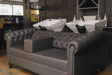 Modern barbershop interior with shampoo wash stations and styling area. Professional salon workspace, clean grooming environment, contemporary design, barber service concept.