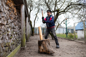 A man chops wood with an axe. Rural housework