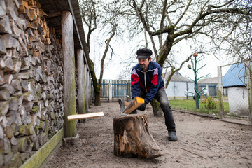 A man chops wood with an axe. Rural housework