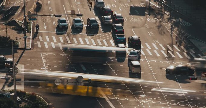 A dynamic urban traffic scene captures vehicles navigating intersections, highlighting the continuous movement and flow of city transportation. Time-lapse, Seoul, South Korea