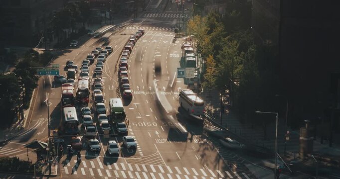 Three frames depict the continuous movement of vehicles on a bustling city street under warm sunlight highlighting the traffic dynamics. Time-lapse, Seoul, South Korea