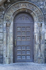 Entrance arched door in stone frame. Vintage style.