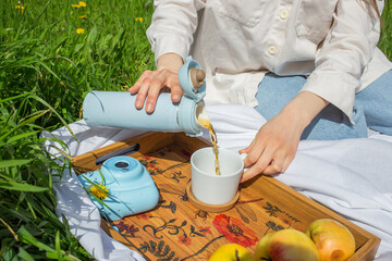 Woman holding a cup of tea picnic