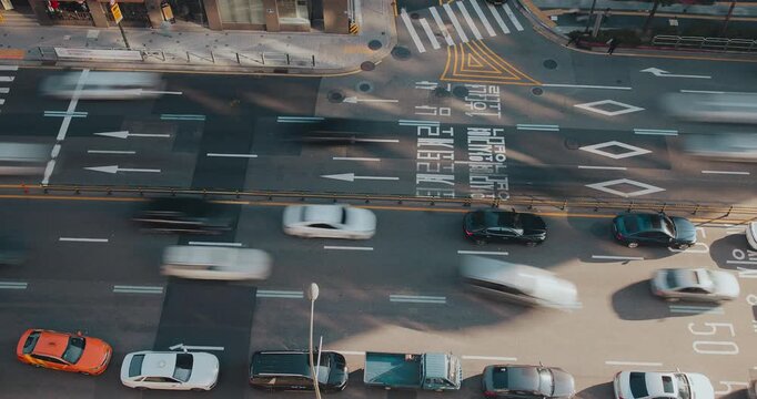 A vibrant urban street captures the continuous movement of vehicles, illustrating the hustle and bustle of city traffic and daily commutes. Time-lapse, Seoul, South Korea