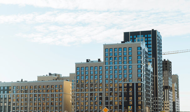 Modern Residential District with Multi-Story Apartment Buildings and Construction Crane under Cloudy Sky